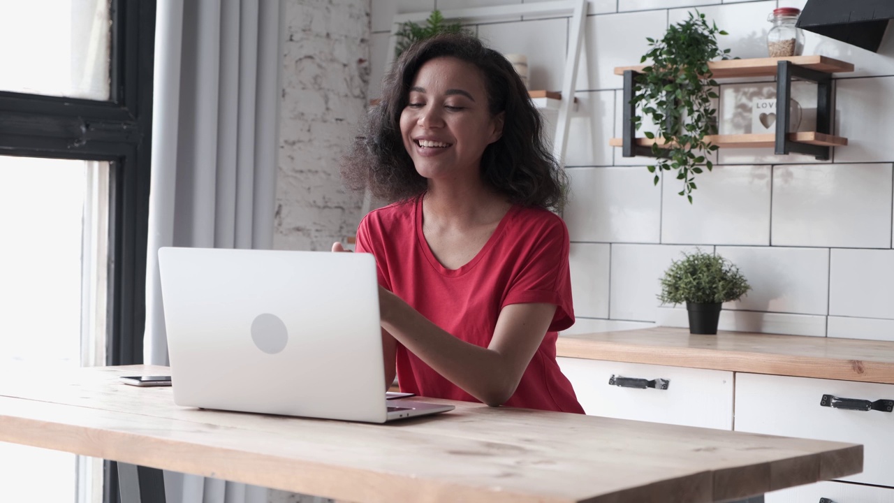 快乐的年轻女性坐在你的笔记本电脑前进行视频通话视频下载