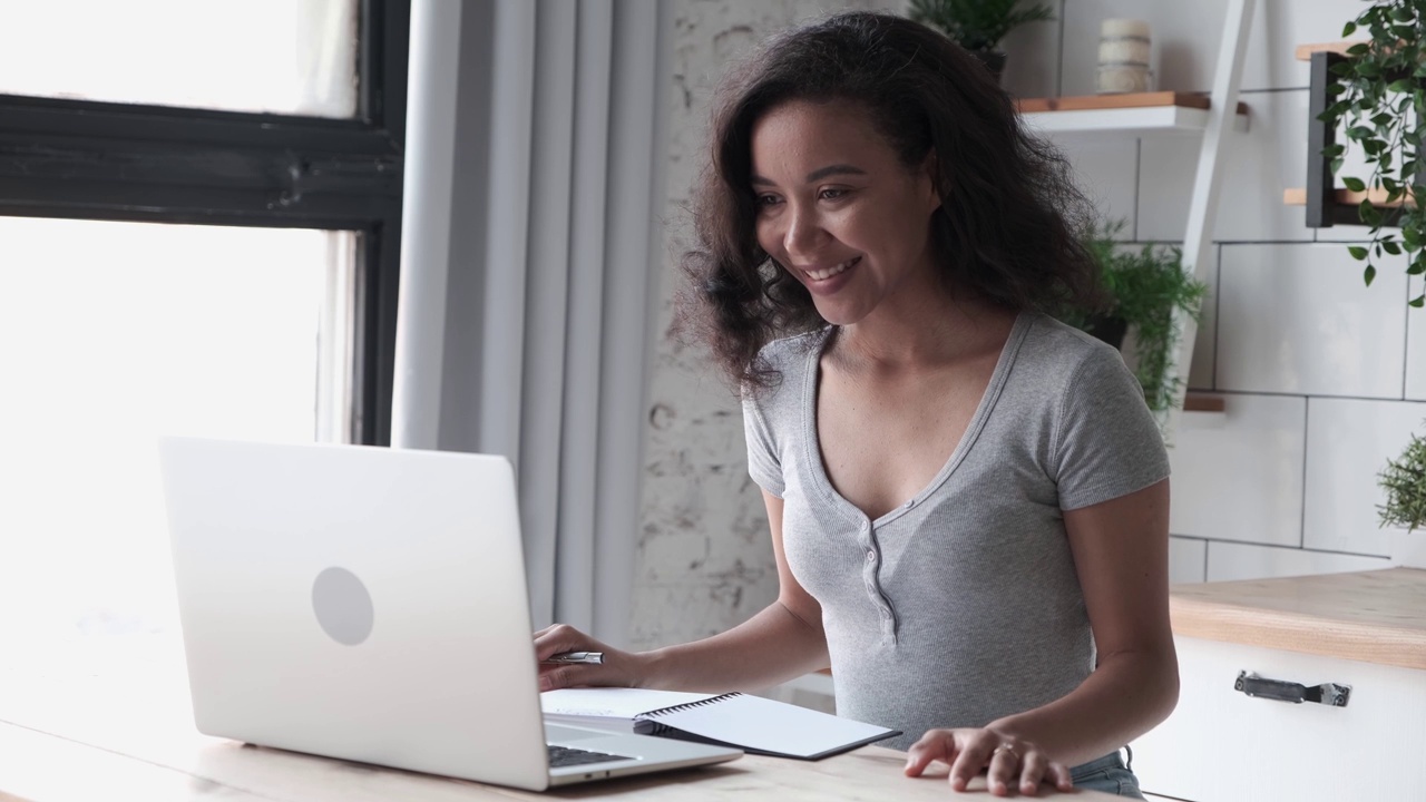 微笑的自由职业者在桌面上使用个人电脑，在家里用笔记本电脑工作视频下载
