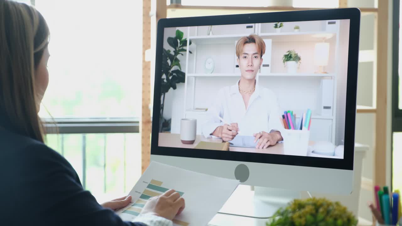 亚洲女商人在视频会议上谈论销售报告。亚洲女性和团队使用电脑进行在线视频会议，在家工作视频下载