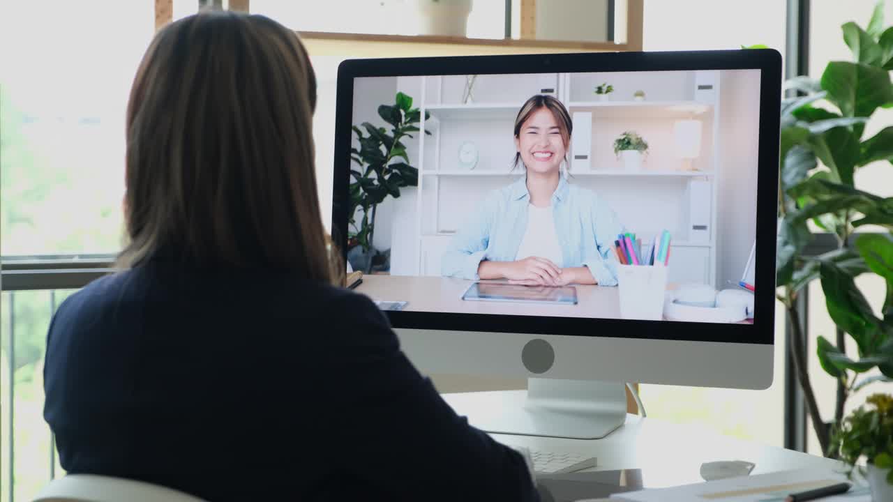 年轻的亚洲女性谈论销售报告和商业计划，在虚拟视频会议上与团队合作，商业电信，在家工作，家庭办公室进行在线视频会议视频素材