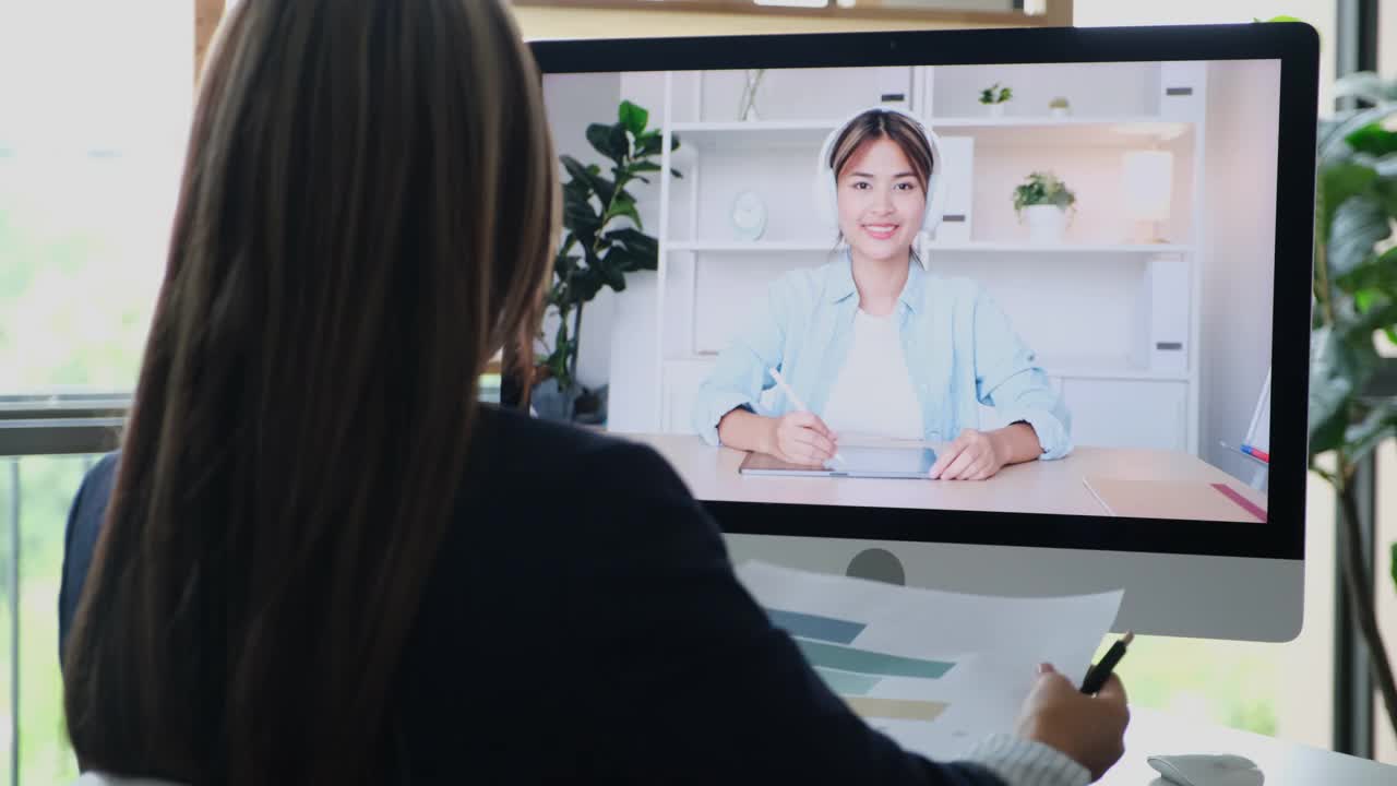 年轻的亚洲女性谈论销售报告和商业计划，在虚拟视频会议上与团队合作，商业电信，在家工作，家庭办公室进行在线视频会议视频下载