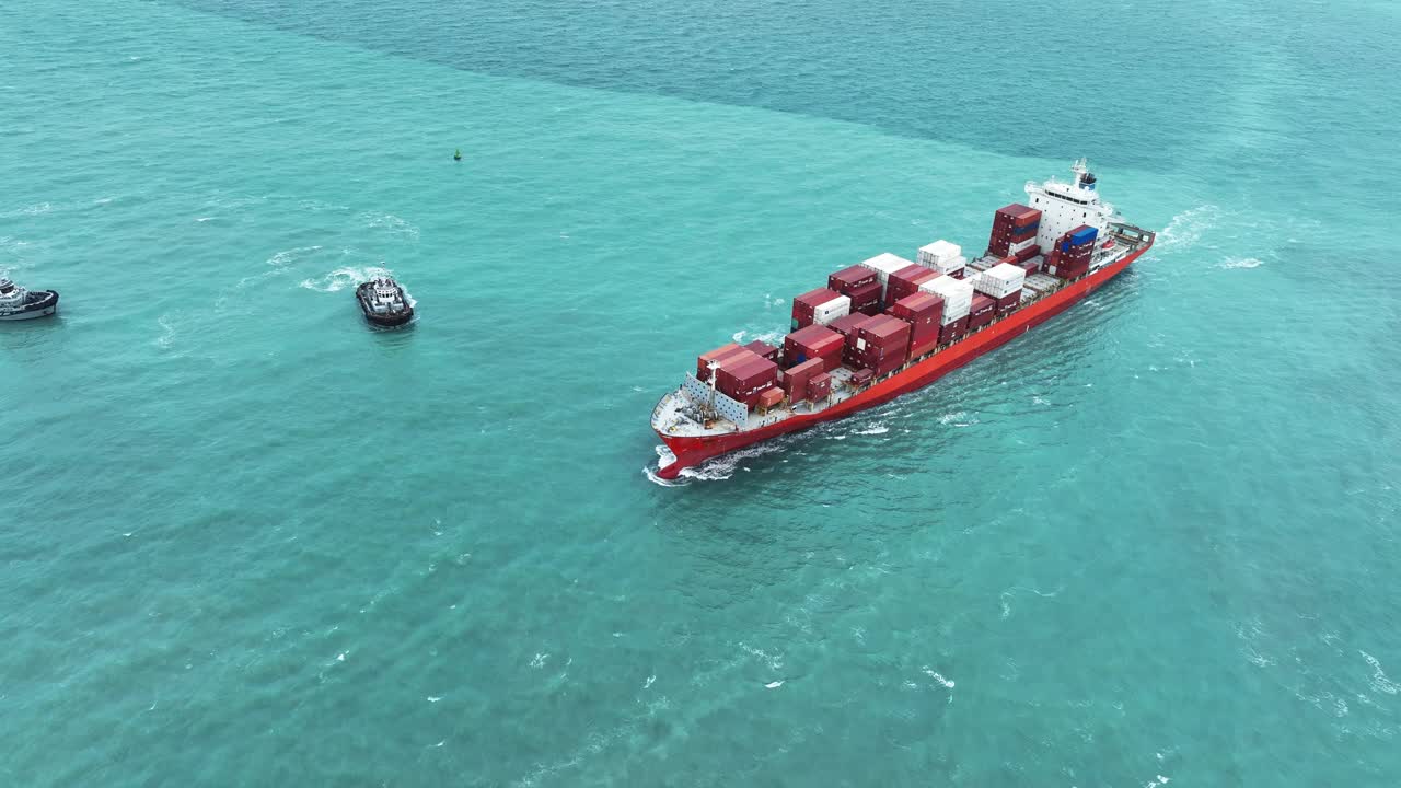 航拍图，货船载着集装箱，与拖船一起从货场港口运进出口货物，以定制海运概念。视频素材