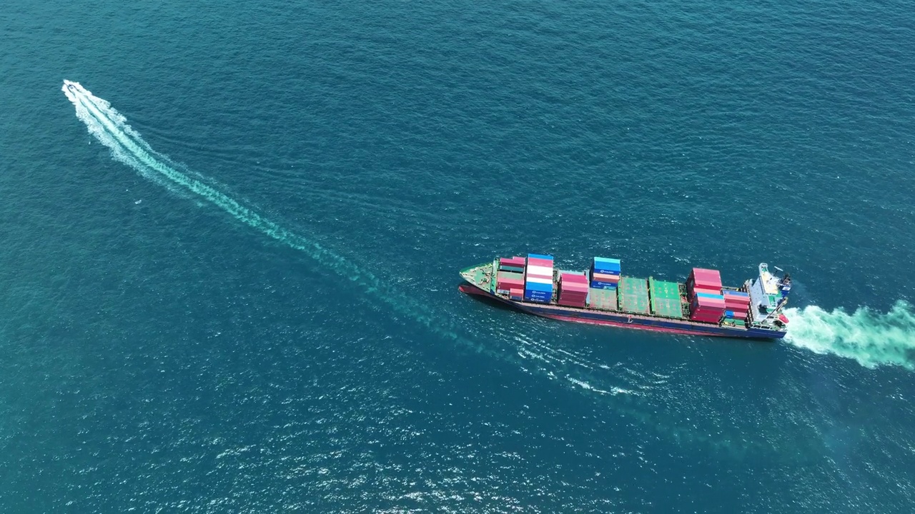 鸟瞰图货船运载集装箱和领航船运行出口货物从货场港口到其他海洋概念货运船。视频素材