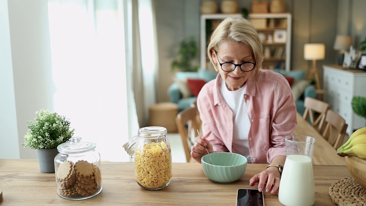 成熟的老年妇女吃健康的早餐视频素材