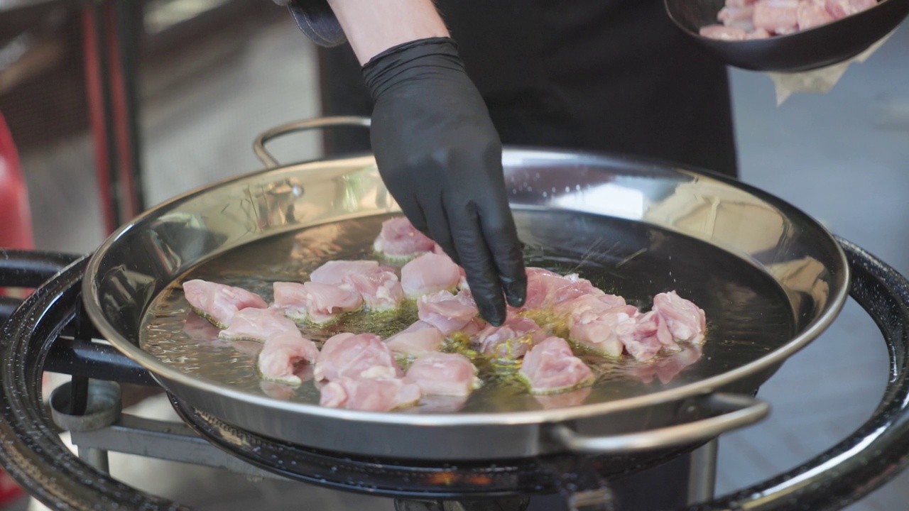 肉在装满食物的厨房里煮熟，鸡肉切成小块放在煎锅里，开着蒸汽，营养早餐视频下载
