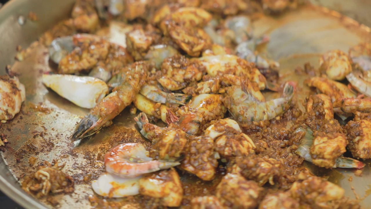 在平底锅里煎虾和鸡柳，用锅铲搅拌视频下载