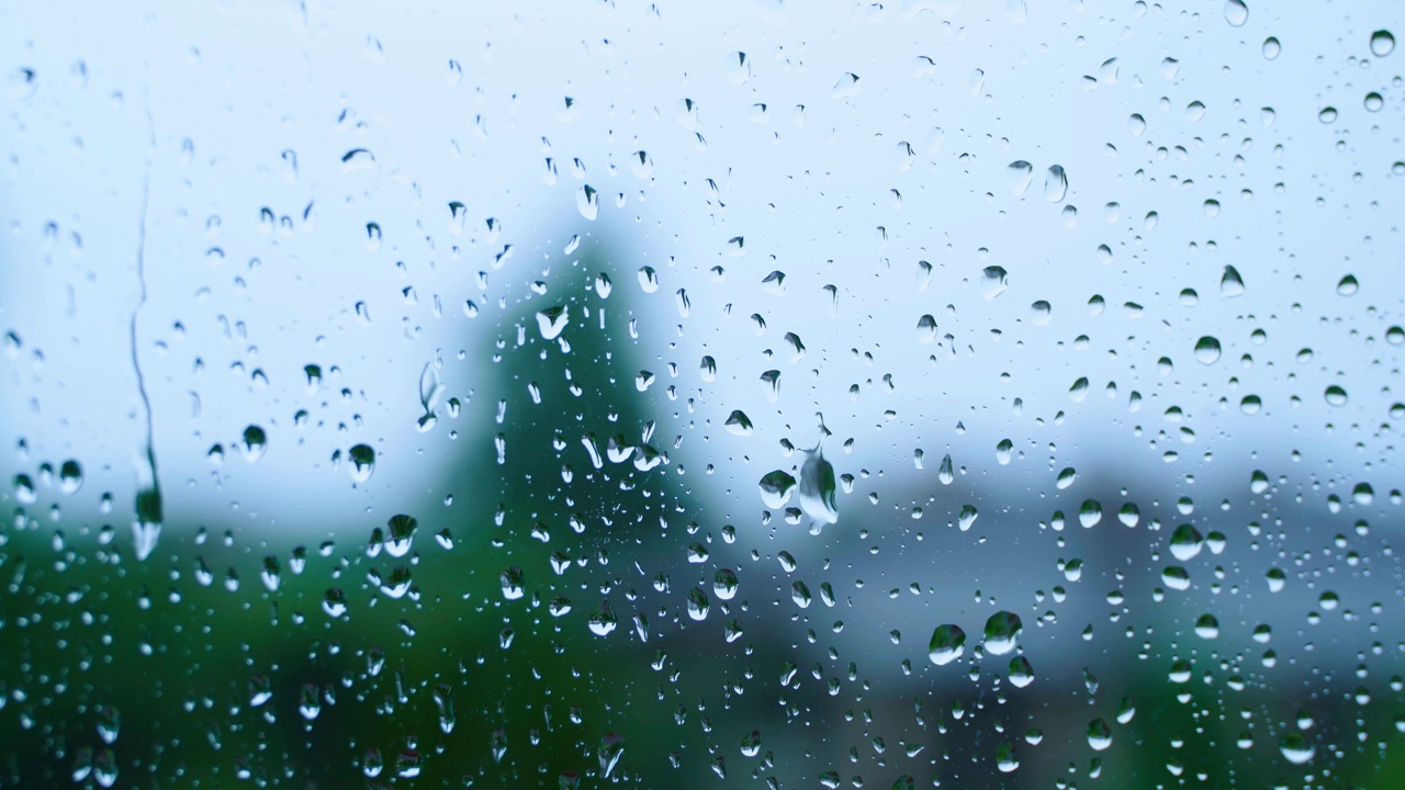 雨滴顺着玻璃特写镜头流下来。秋雨的背景，壁纸视频素材