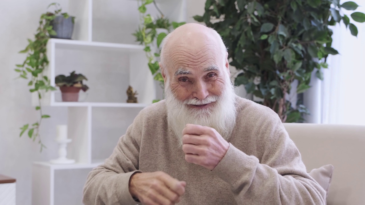 一位满脸胡须的退休老人对着镜头做着有趣的手势视频下载