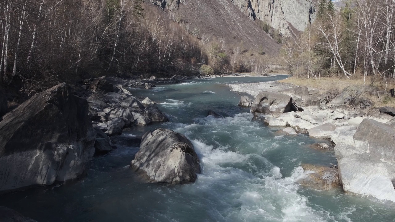 沸腾的水迅速流过石头。秋天的山河，慢动作视频下载