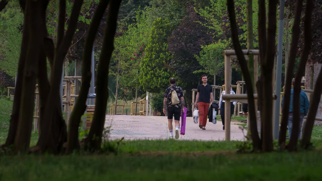 人们在公园的绿树中散步的时间流逝。视频下载