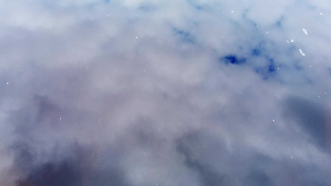 鸟瞰图。视频4k PRORES HQ。蓝天白云映在湖水中。自然背景与复制空间与河流表面和蓝色多云的天空在热带地区。视频下载