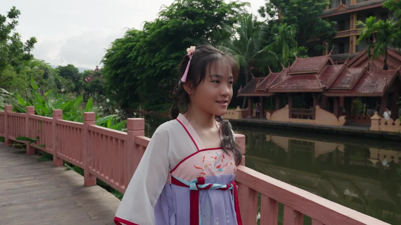 穿着汉服的亚洲女孩在公园里拍照视频下载