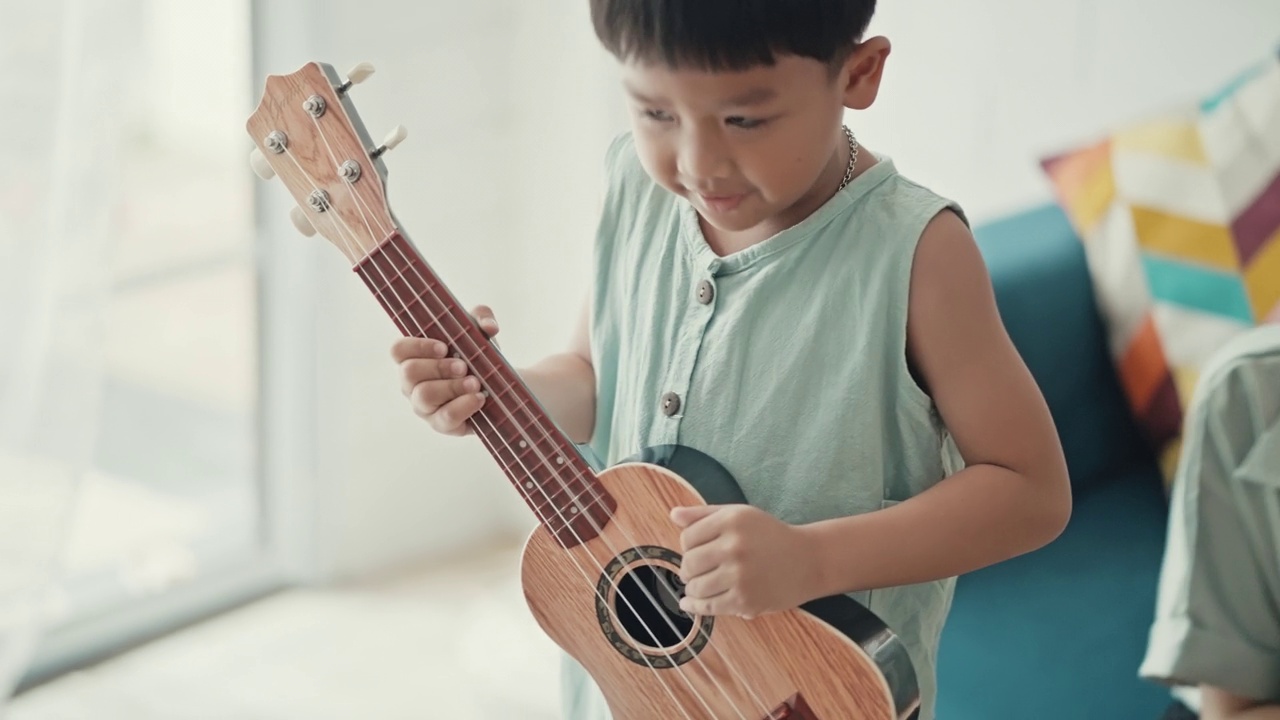 快乐的亚洲家庭在家里唱歌和弹吉他视频素材