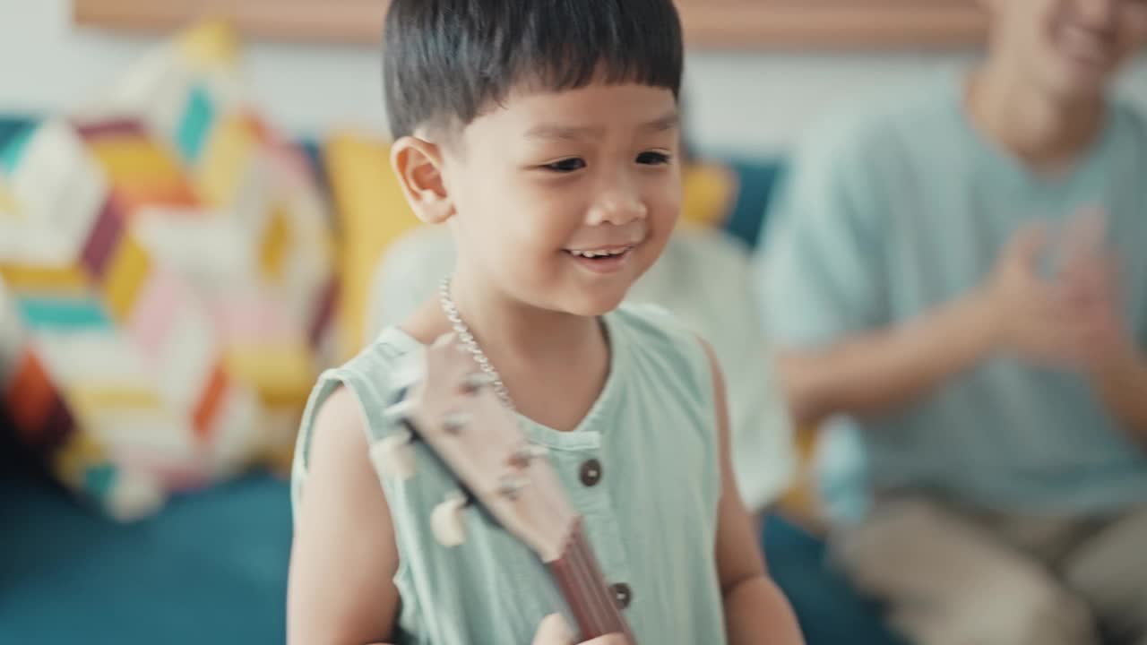 快乐的亚洲家庭在家里唱歌和弹吉他视频素材