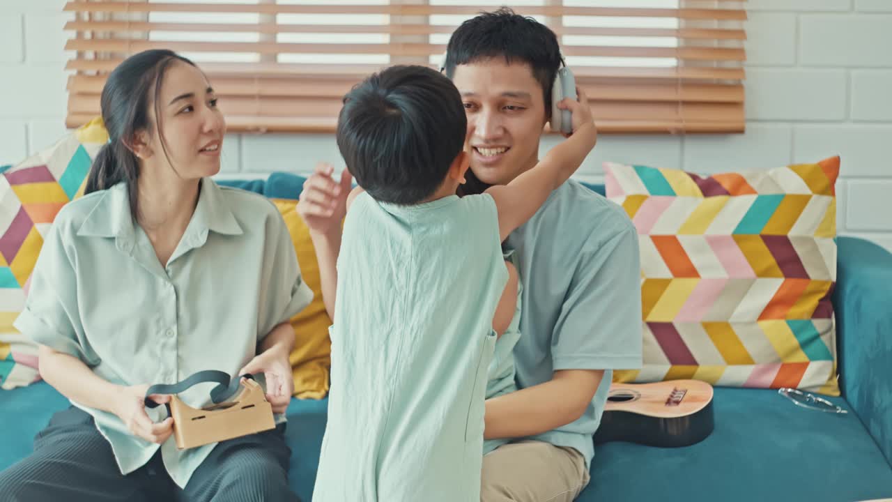 快乐的亚洲家庭在家里使用耳机视频素材