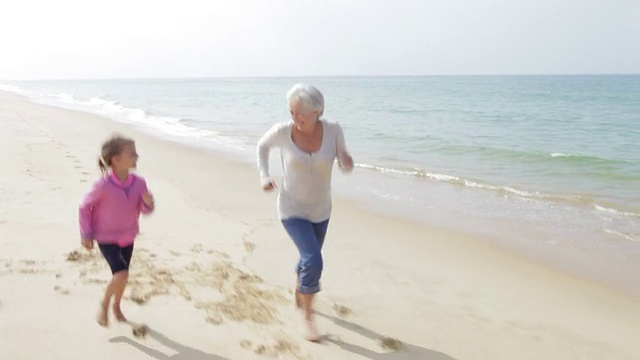 祖母和孙女一起在海滩上跑步视频下载