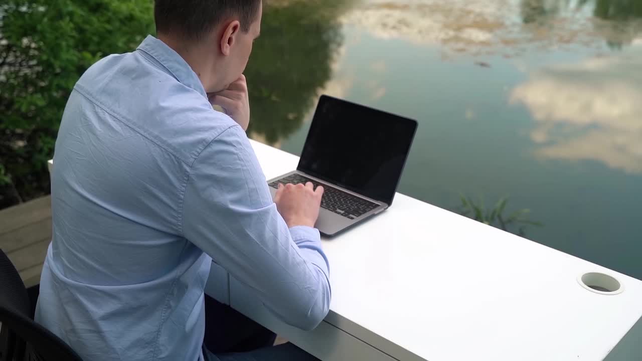 一名男子在户外用笔记本电脑工作视频下载