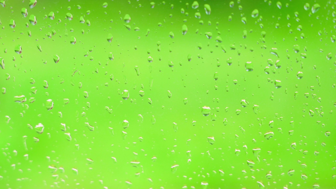 雨滴落在绿色背景的窗户上，特写视频素材