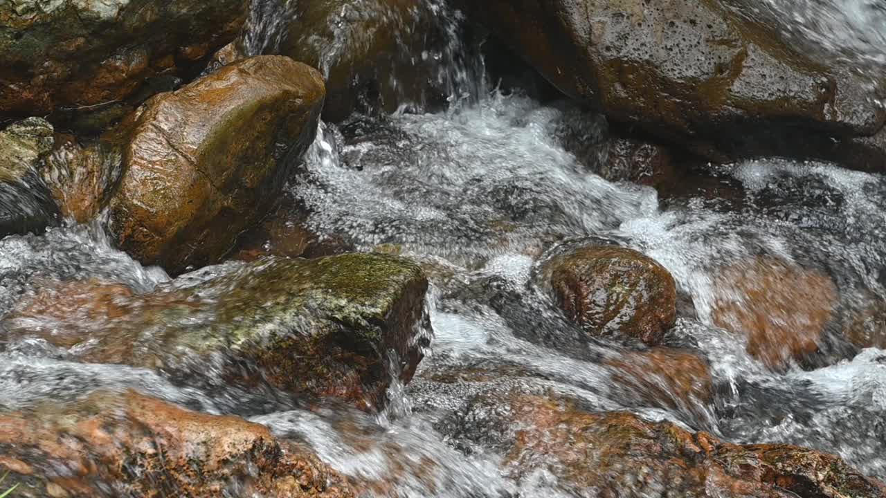 山涧间的岩石在峡谷中流淌，湍急的水流沸腾而起泡沫视频下载