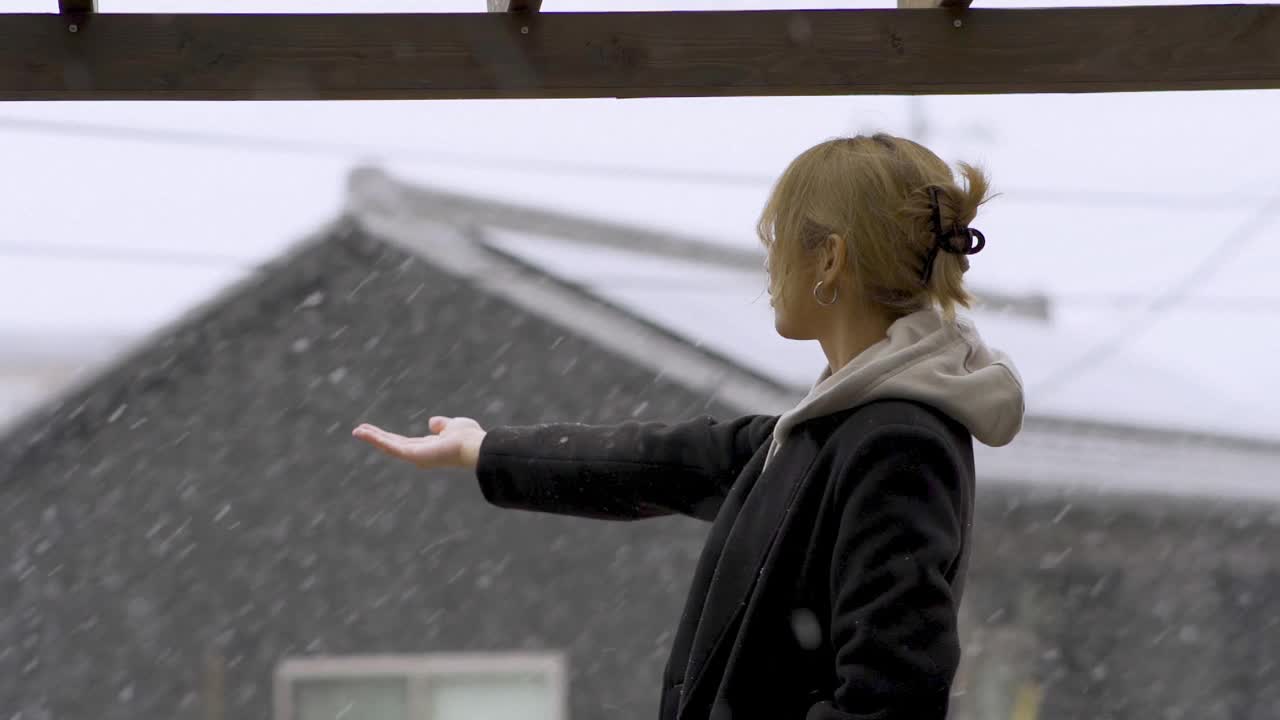 亚洲华人妇女在后院享受下雪视频下载