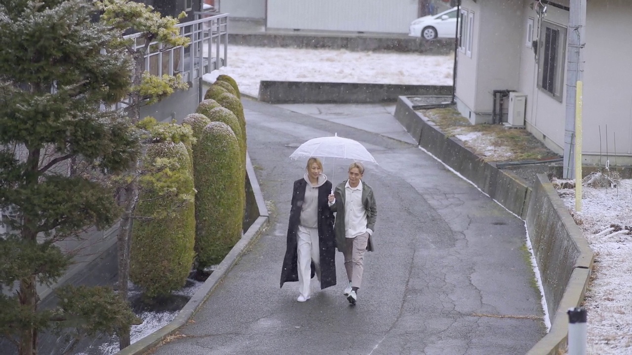 一对亚裔华人夫妇带着雨伞在雪中散步视频下载