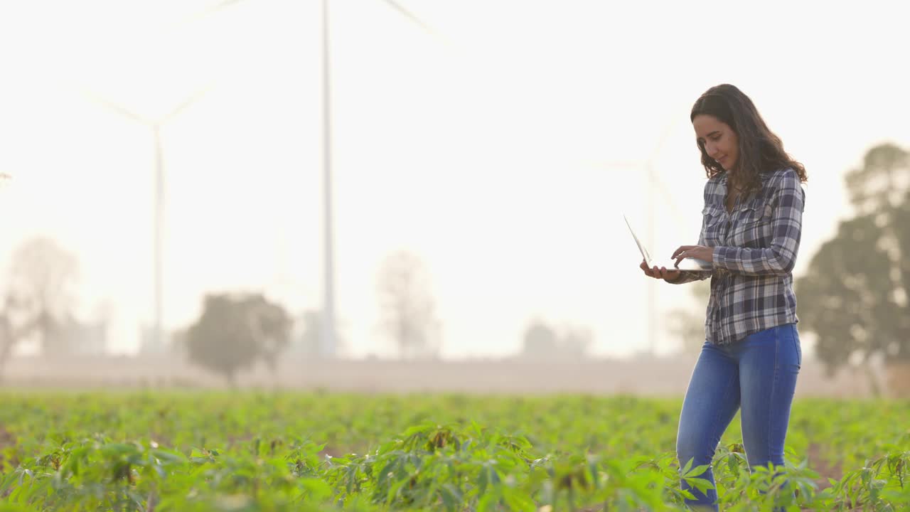 慢动作西班牙裔妇女农民手里拿着笔记本电脑研究可持续性和增长分析。农业、种植园和园艺概念视频下载