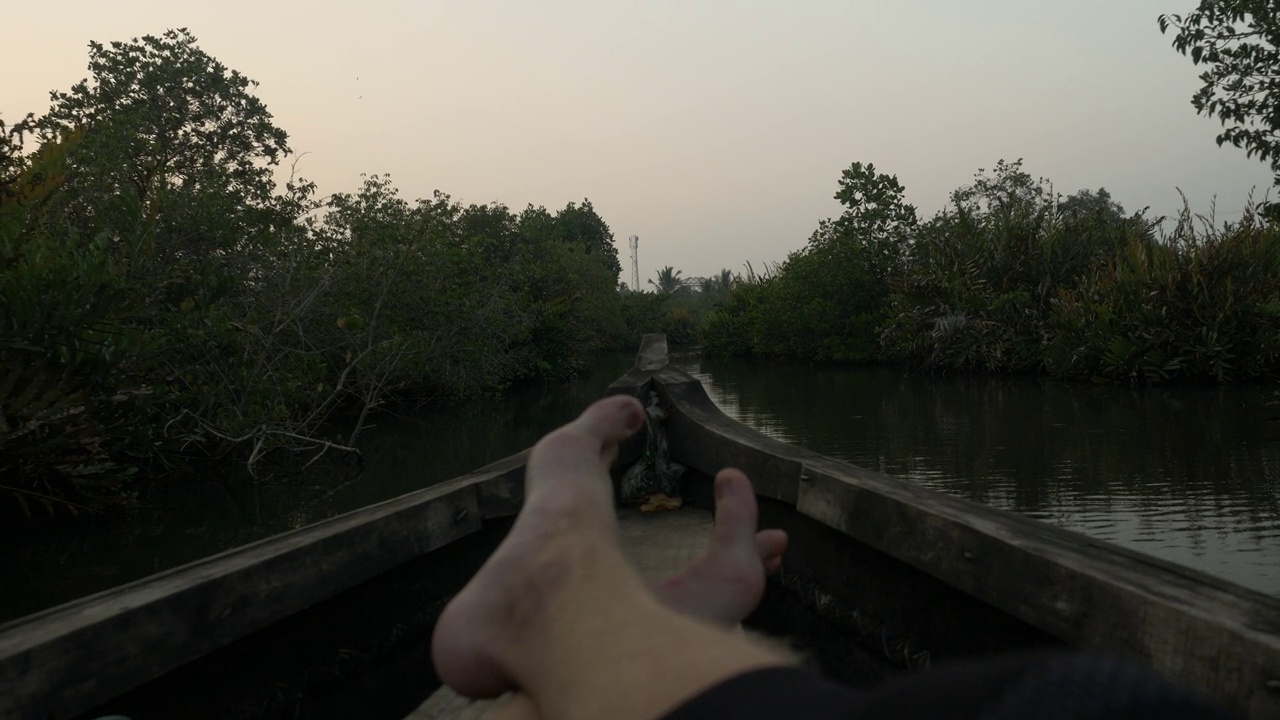 一名游客漂浮在河上的木船上，以第一人称的视角欣赏印度喀拉拉邦芒罗岛的丛林。视频素材