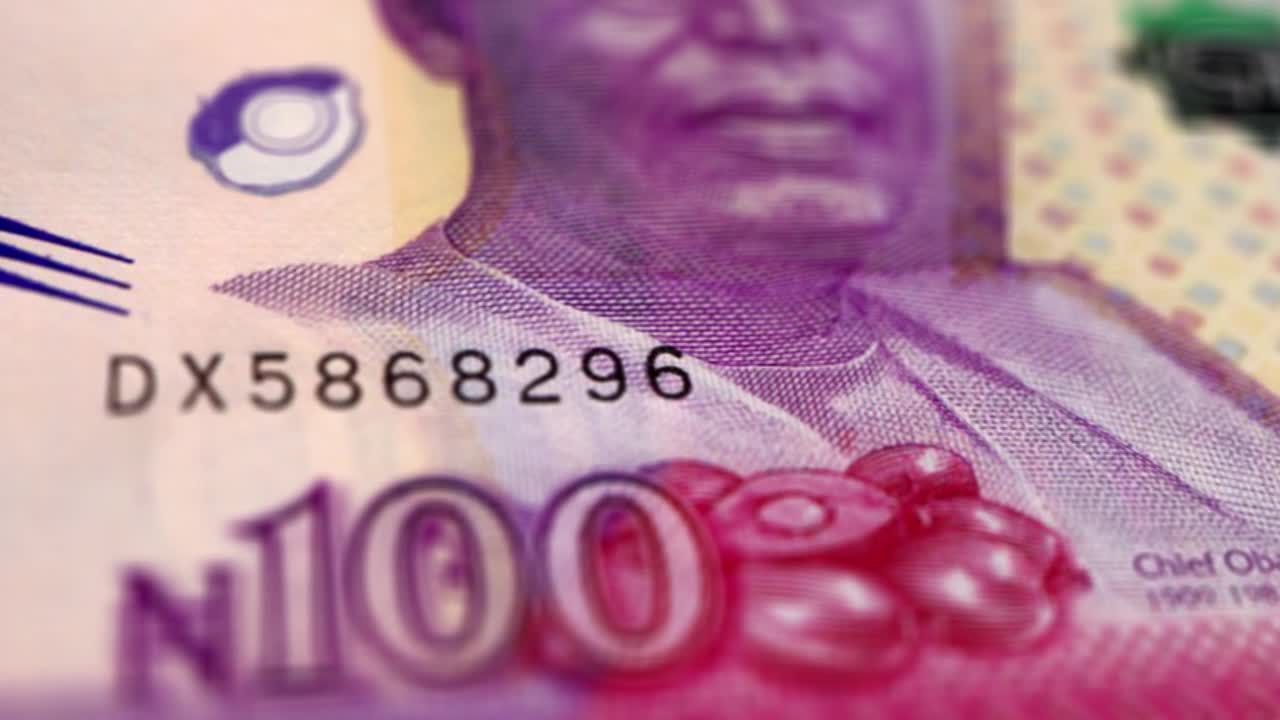 尼日利亚奈拉100钞票，一百尼日利亚奈拉，尼日利亚奈拉的特写和宏观视图，跟踪和多莉拍摄100尼日利亚奈拉钞票观察和储备方面，尼日利亚奈拉货币背景，尼日利亚视频下载