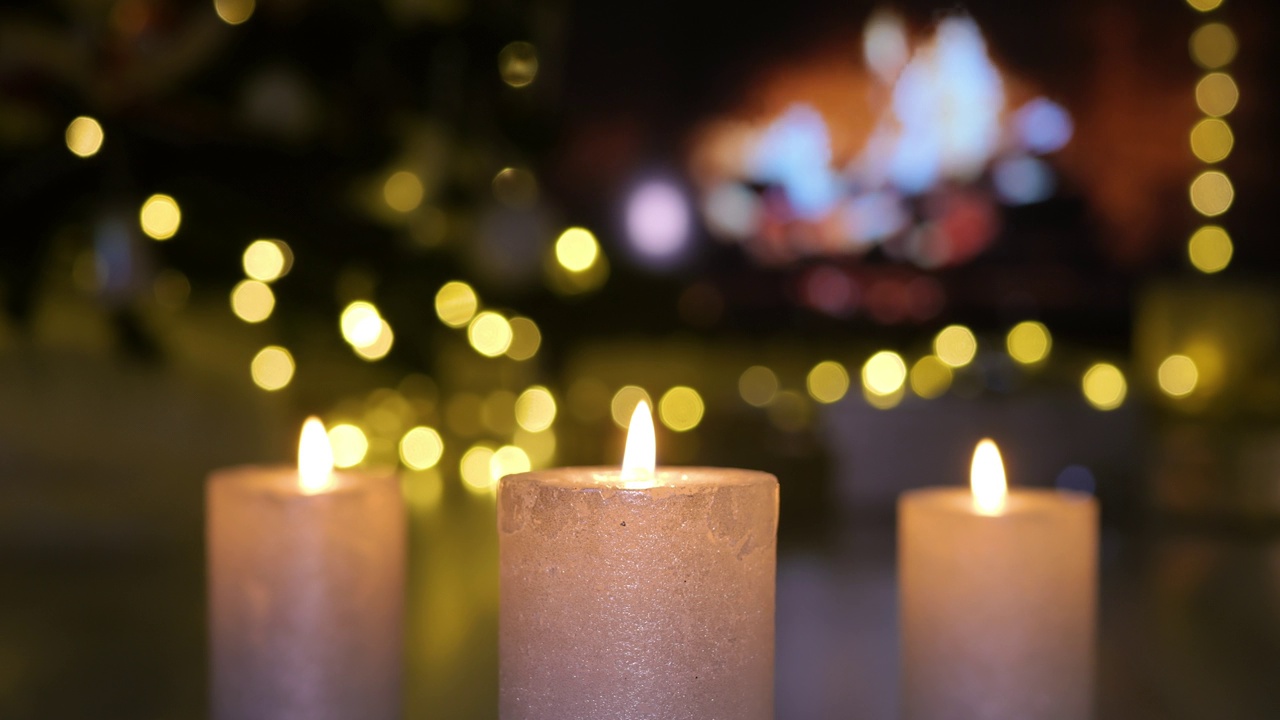 圣诞蜡烛在壁炉前燃烧，在大气的灯光下视频下载