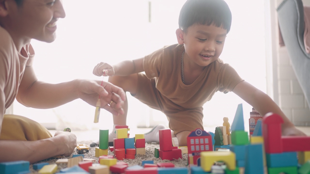 亚洲儿童在温暖的地板上玩木块视频素材