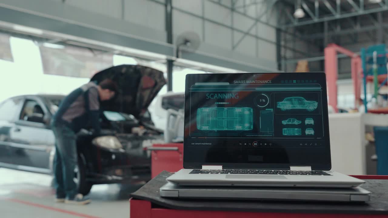 汽车维修技师使用装有汽车诊断软件的笔记本电脑。汽车电子诊断应用。视频下载