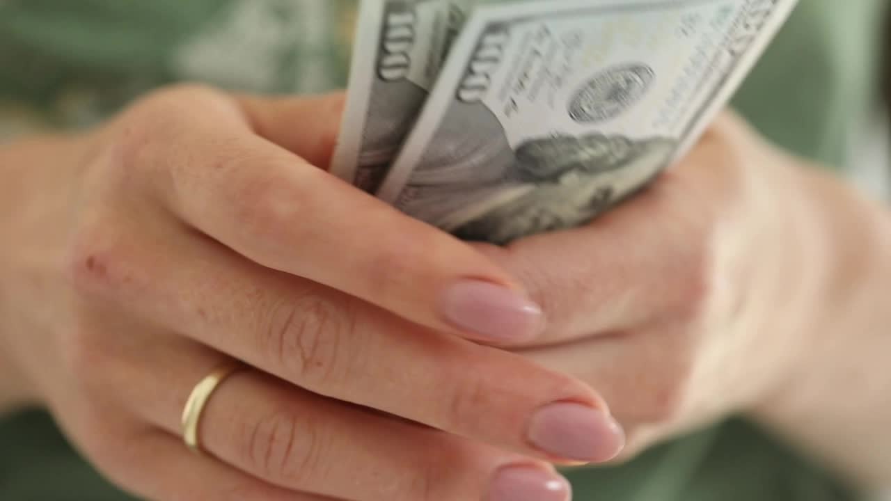女性的手数着美元。前视图。美元钞票特写。手头有钱。视频下载