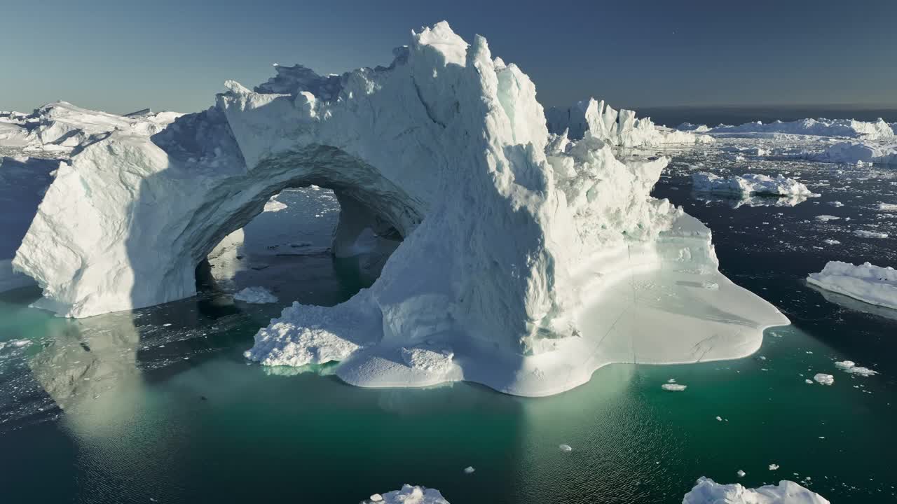 巨大的冰山和冰洞在海洋中融化。融化冰川的冰山漂浮在格陵兰岛伊卢利萨特附近的迪斯科湾。航拍，气候变化的概念视频下载