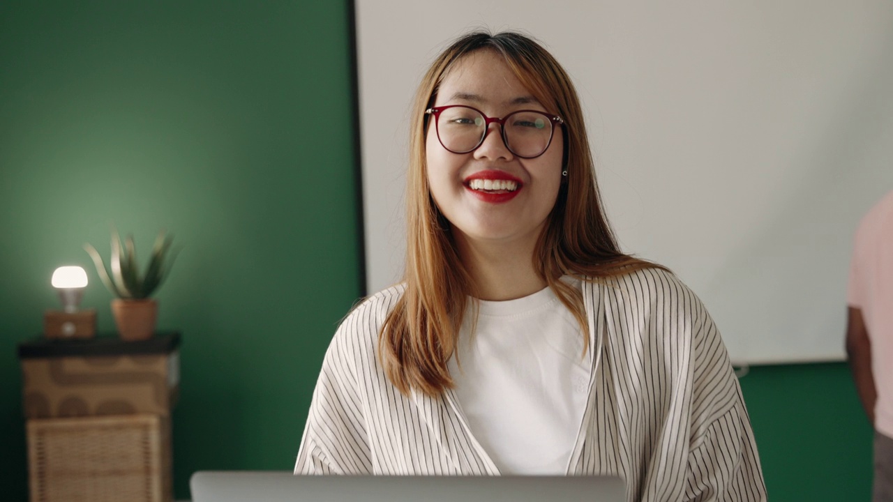 微笑的年轻中国女商人在现代办公室的肖像视频下载
