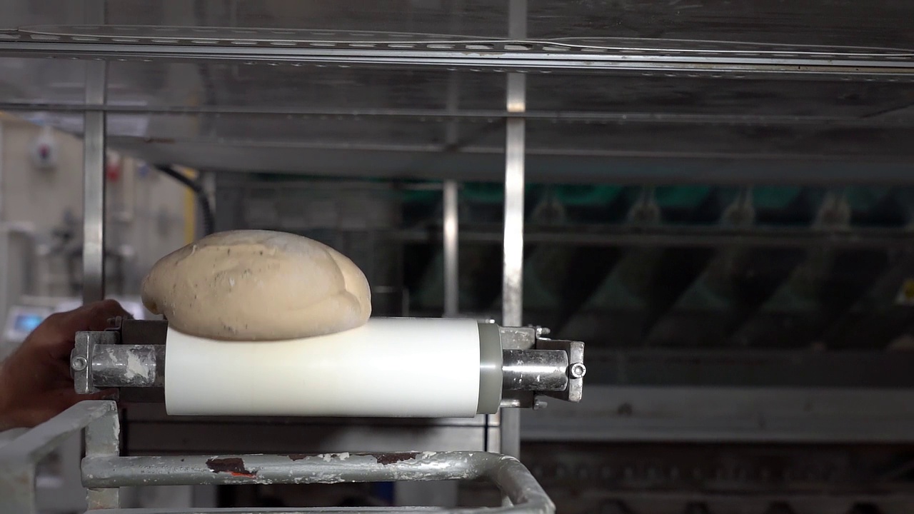 工业烘焙生产线上的面包面团-慢动作视频。视频素材