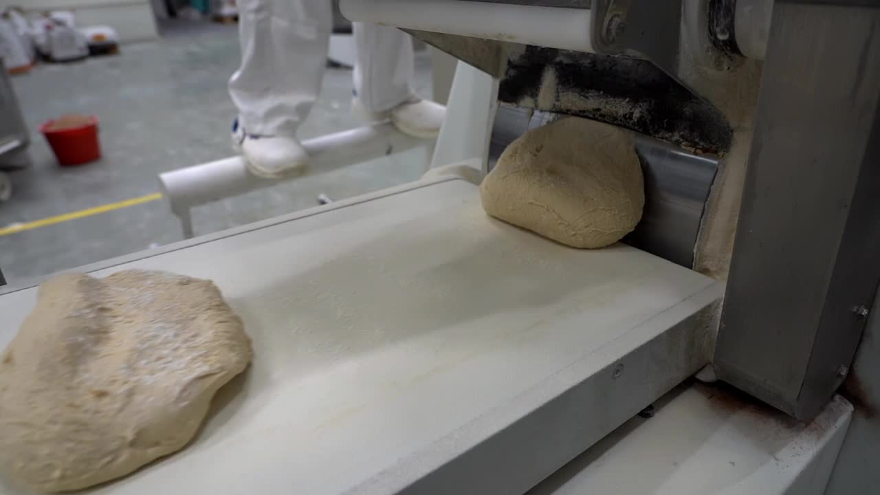面包面团沿着工业烘焙生产线输送机移动的慢动作视频视频素材