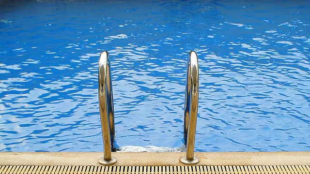 梯子在蓝色的游泳池视频素材