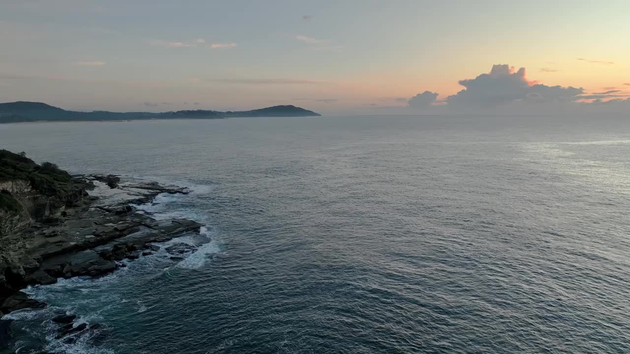 在海上和岩石平台上鸟瞰日出视频下载