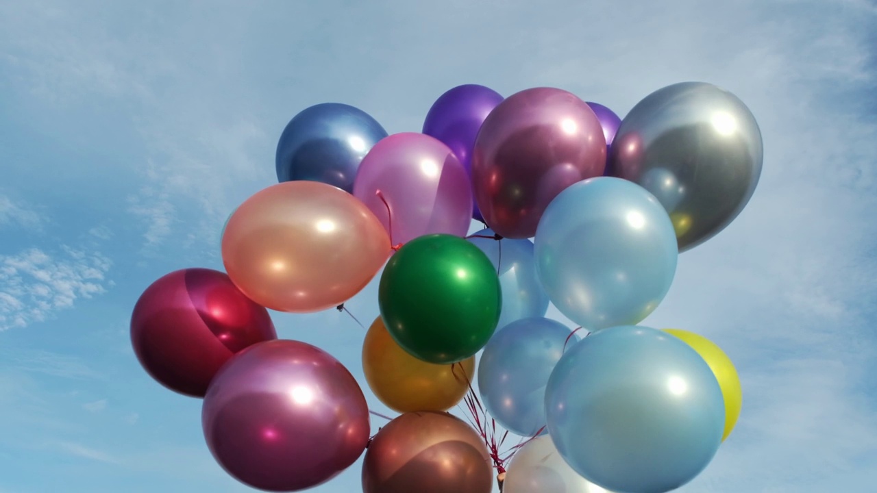 蓝天下五颜六色的氦气气球。视频下载