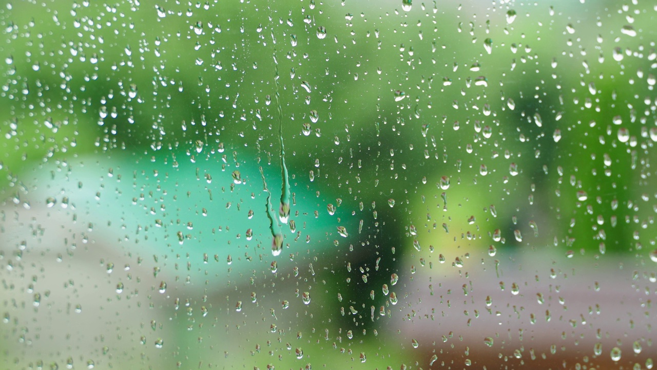 下雨天的特写窗口，背景模糊。背景以秋天为主题视频素材