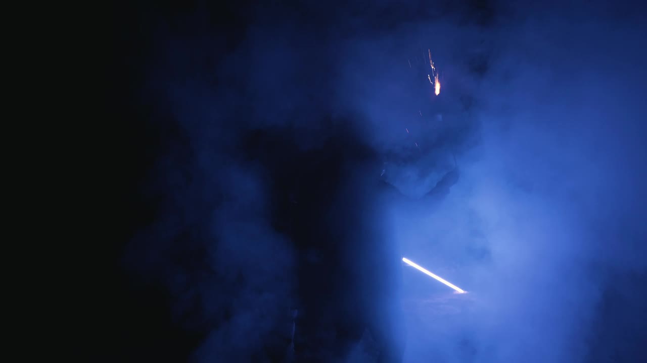不明特技人员在黑暗中旋转燃烧的火炬冒烟视频素材