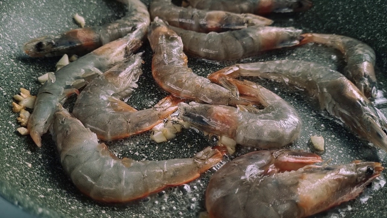 新鲜的虎虾，用煎锅煎，用大蒜和香料油煎，移动视频，视频素材