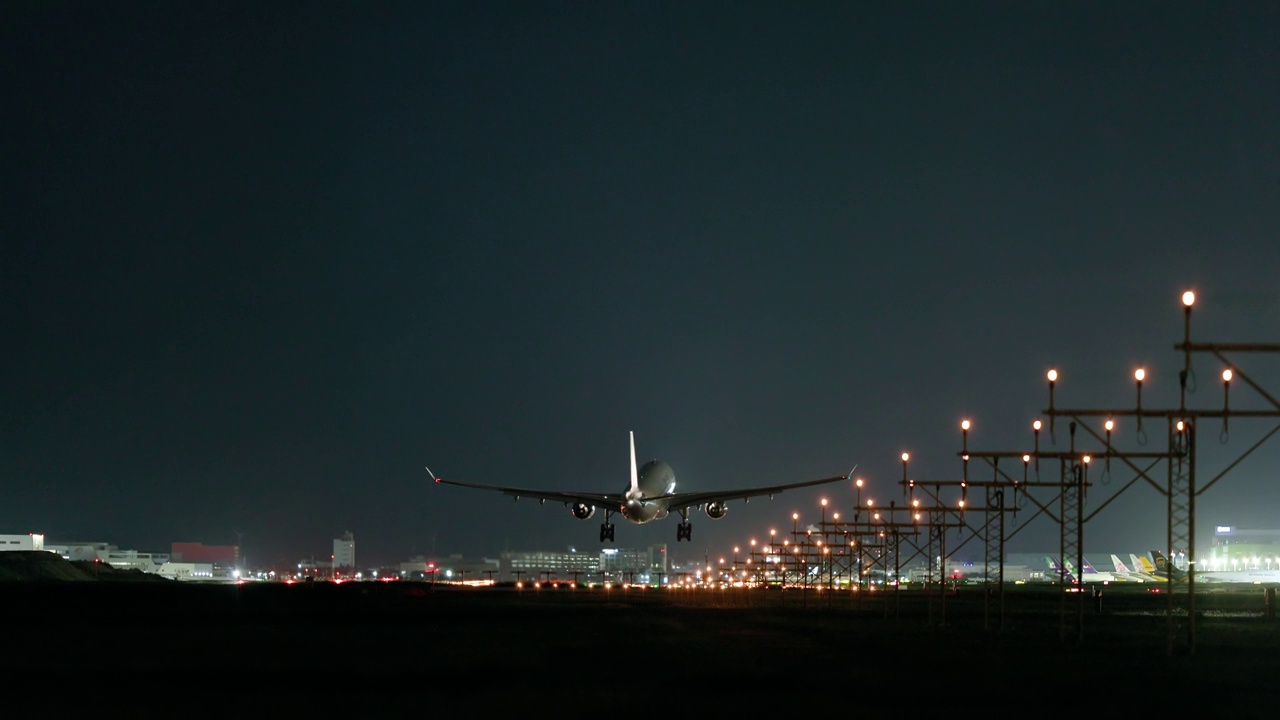 飞机在夜间降落在机场跑道上视频素材