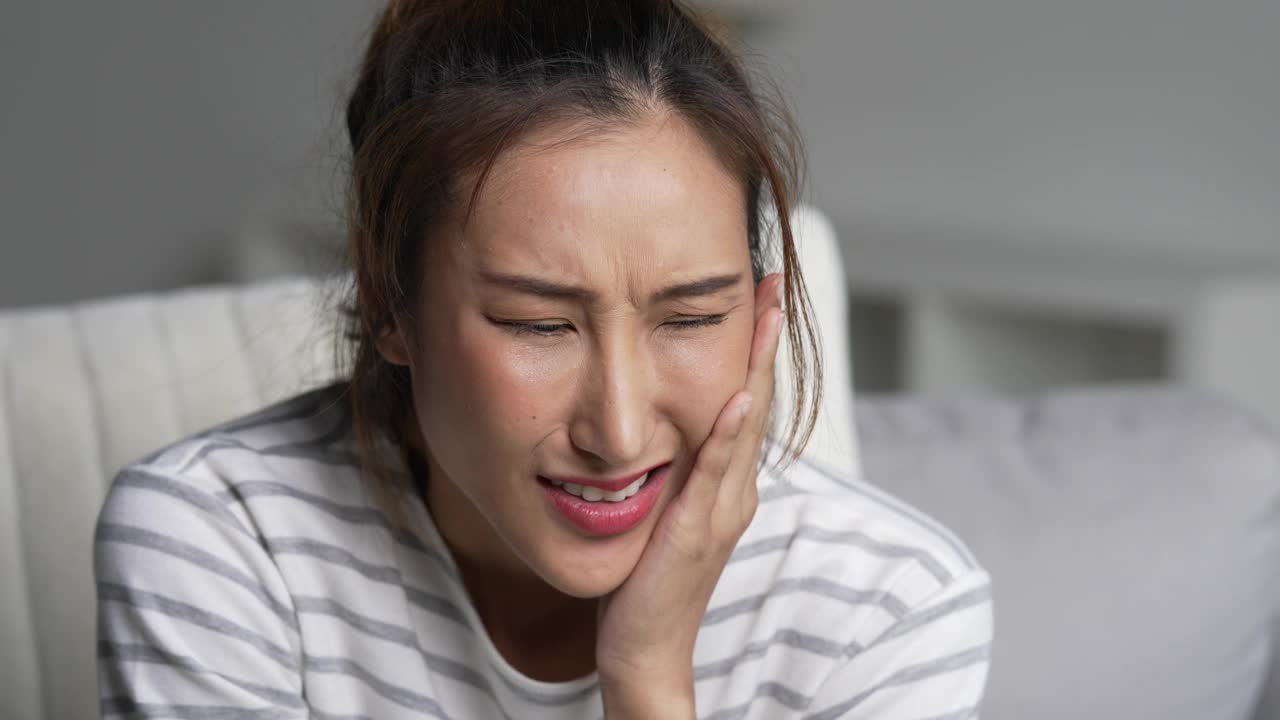 患有牙痛的年轻亚洲女性。视频下载