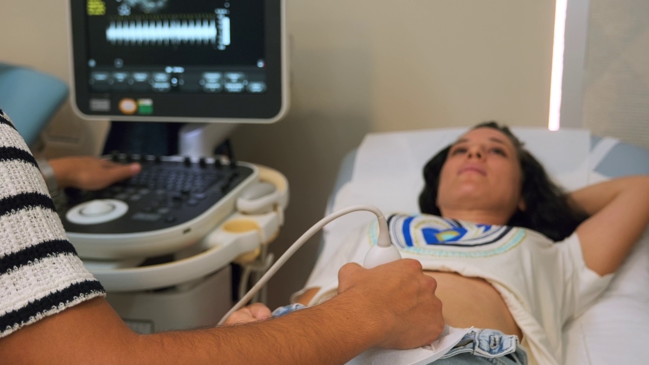 在医院里，年轻的孕妇在医生的超声波检查中听到了孩子的第一次心跳。视频下载