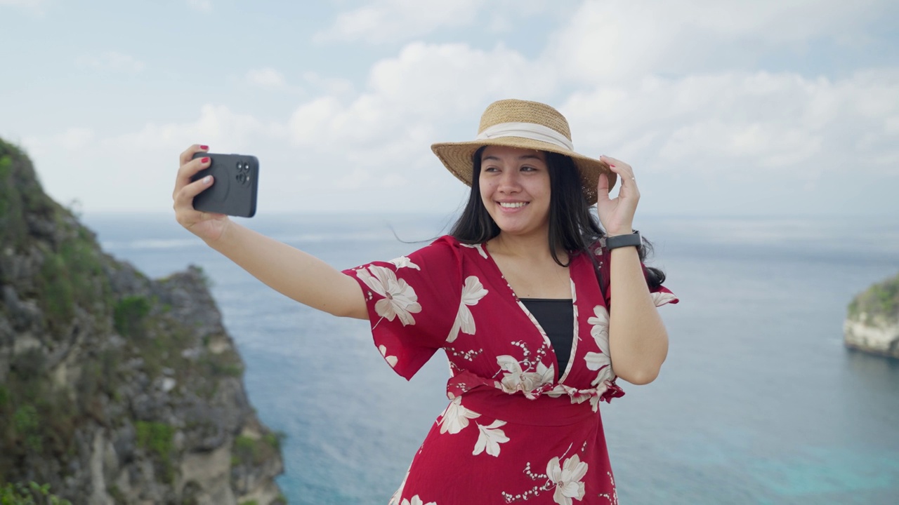 在努沙佩尼达岛钻石海滩，年轻女游客与大自然拍照的4K视频。印尼巴厘岛的热门旅游目的地。视频素材