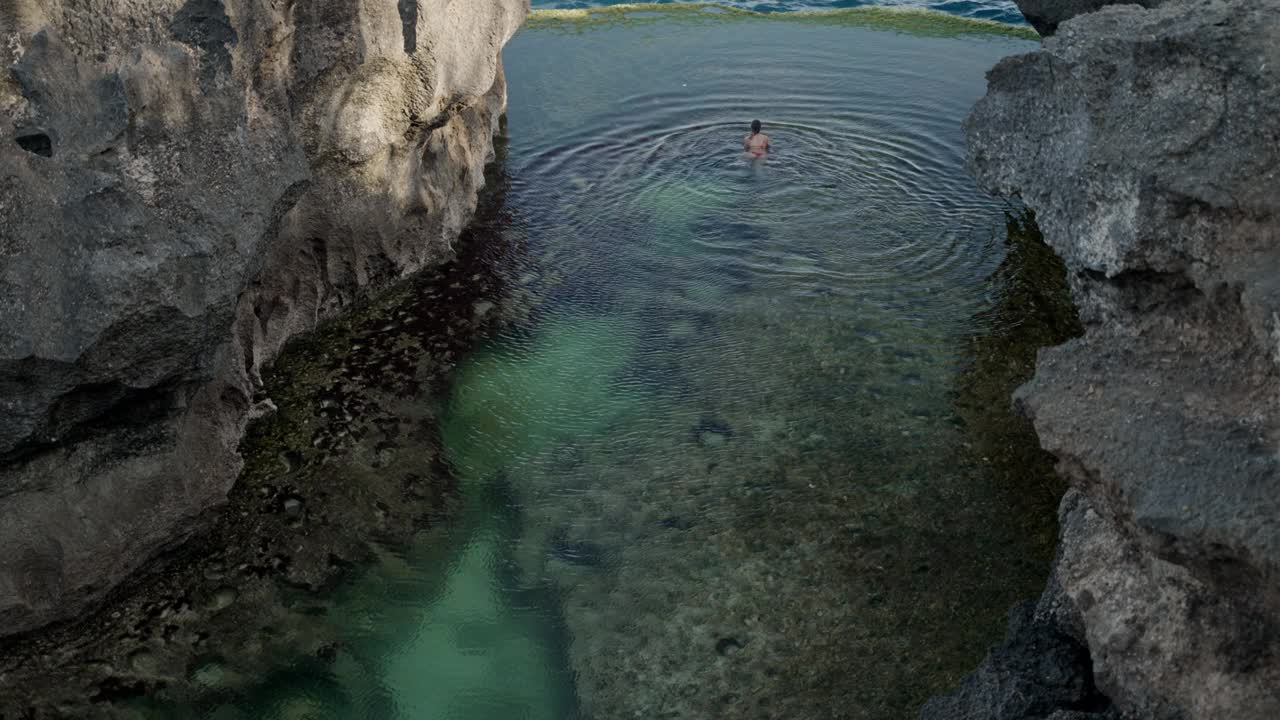 游客在印尼巴厘岛努沙佩尼达破碎海滩附近的天使比拉邦游泳的4K视频。视频下载