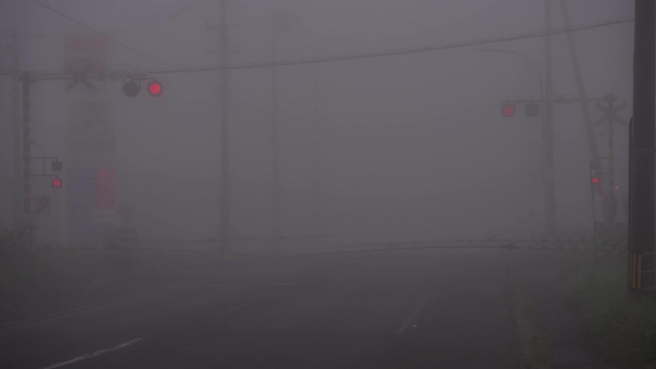 日本北海道Nemuro，黎明时分，一列火车在浓雾中驶过铁路道口视频素材