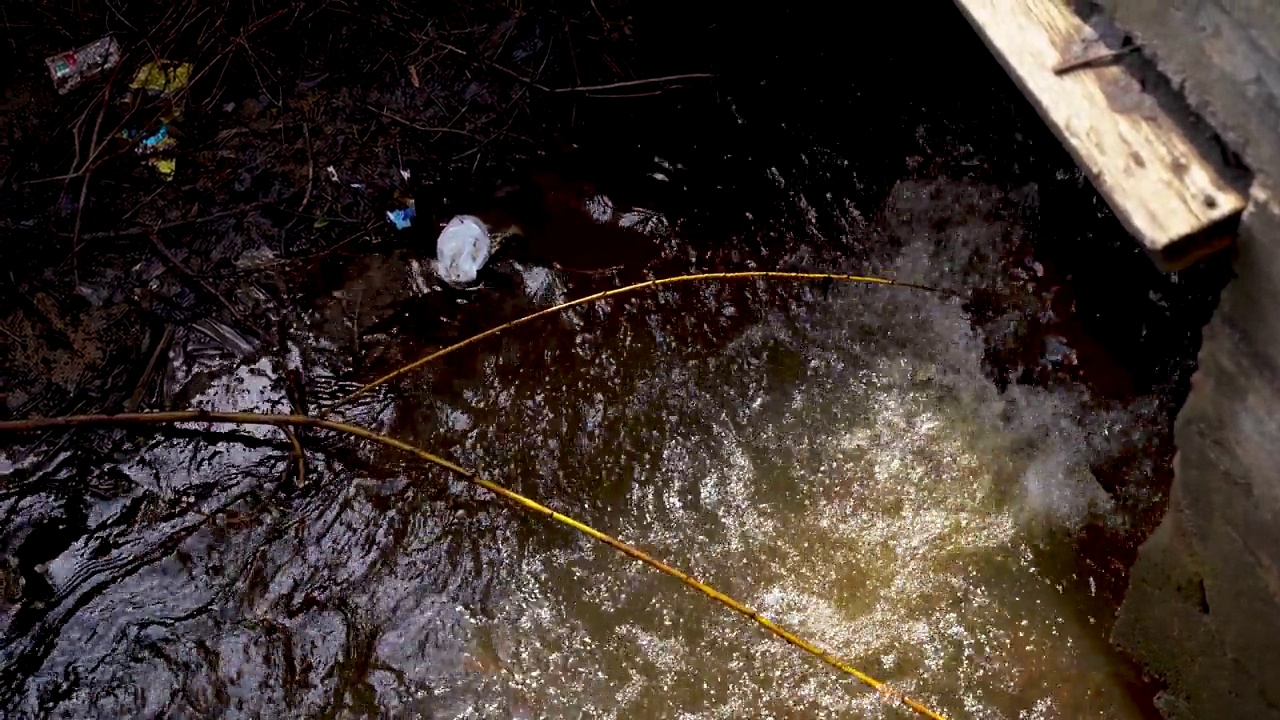 脏水从管道流入河流，污染环境。视频素材