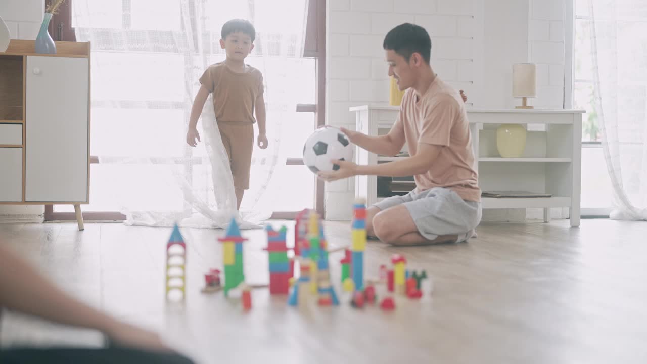 亚洲男孩踢球和破坏玩具木块。和家人一起玩视频下载